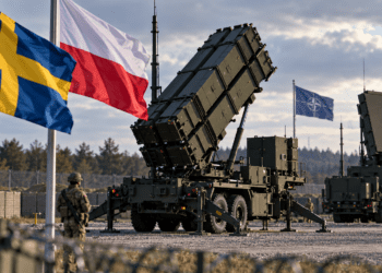 Patriot air-defence launcher with Swedish, Polish and NATO flags at a generic military site