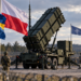 Patriot air-defence launcher with Swedish, Polish and NATO flags at a generic military site