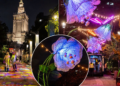 Editorial photo collage showing the illuminated Palace of Culture and Science, projected colours on a park walkway and glowing floral light installations in Warsaw; not a photograph of the 15 October opening ceremony.