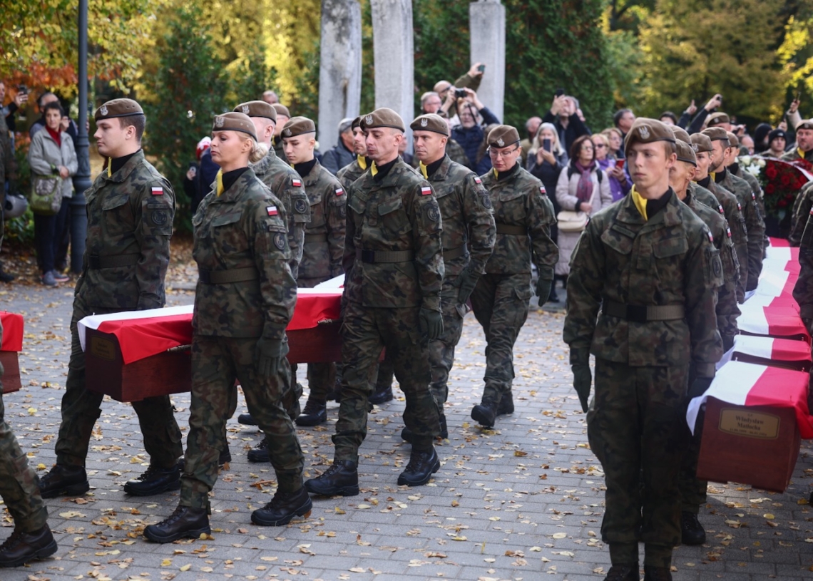 Polish soldiers carry flag-draped coffins during the state funeral for 49 victims of communist repression at Wrocław's Osobowicki Cemetery.