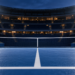 Digitally created illustration of an empty blue hard-court tennis stadium under floodlights, with sports bags and rackets beside the net.